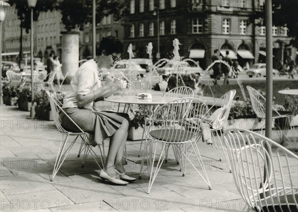 Bayreuth in 1963: a young woman sits on the terrace of a street cafe eating an ice cream