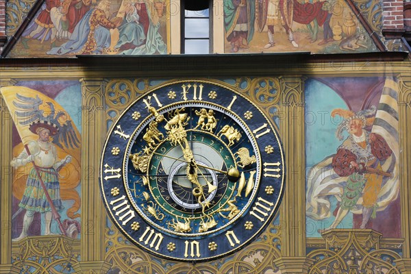 Richly decorated astronomical clock with signs of the zodiac on the town hall