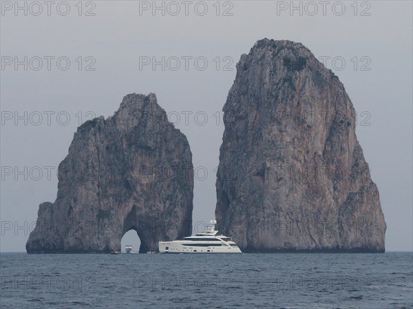 Yacht in front of Faraglioni rock group