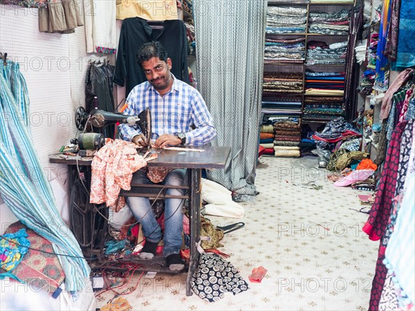 Tailor sewing a garment on a sewing machine