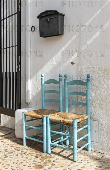 Two chairs in front of white house