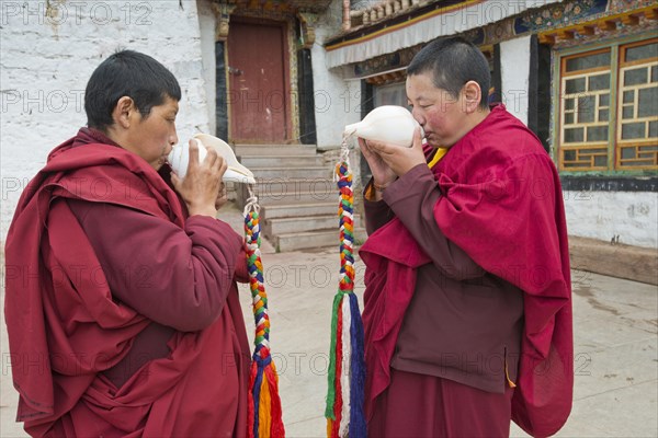 Buddhist nuns in the Terdom monastery call with the conch horn