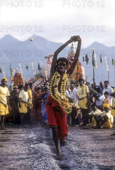 A god possessed man running on burning coal