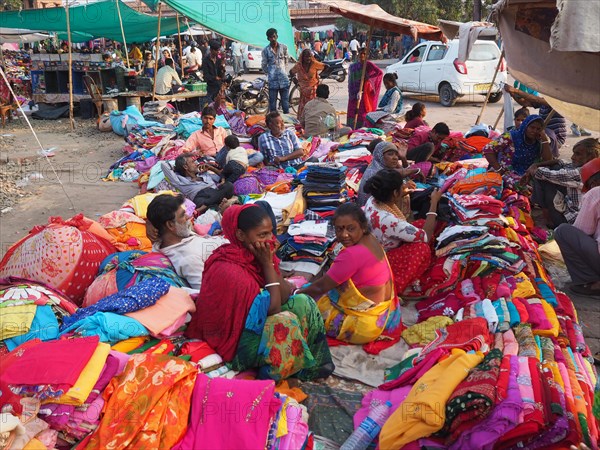 Vendor offering textiles at market stall