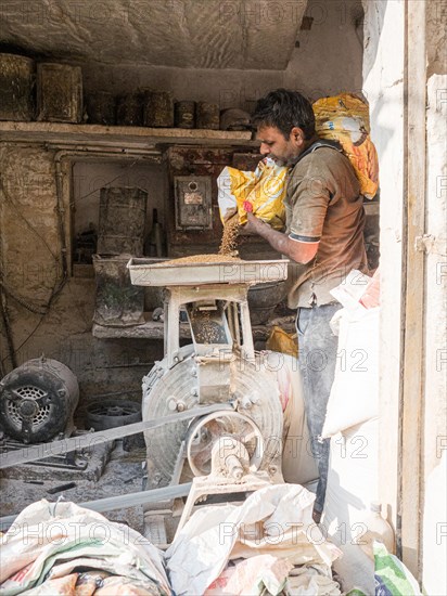 Vendor grinding fresh flour at market stall