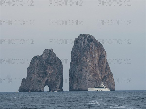 Yacht in front of Faraglioni rock group