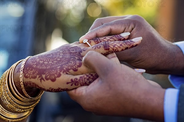 Engagement ring ceremony of a Mauritian Hindu couple. Groom passing ring in his bride`s finger