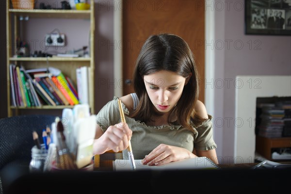 Young teenage girl painting