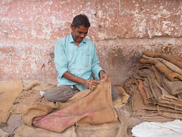 Worker sewing sacks