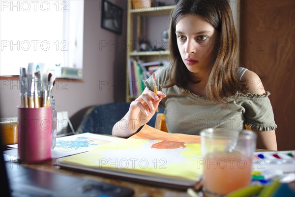 Young teenage girl painting