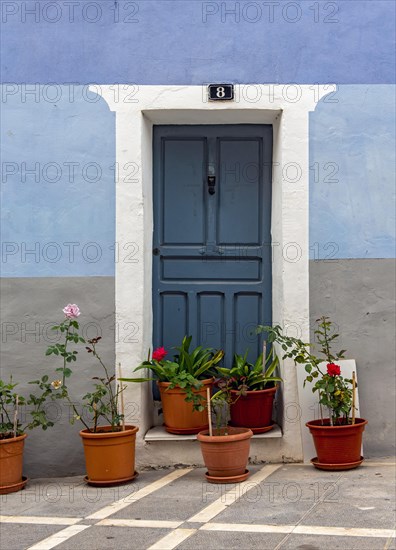 Blue door and house with flowerpots