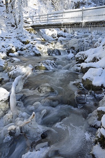 Bridge with icicles and frozen stream