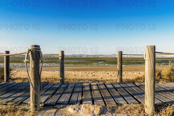 Wooden walkways with view on wetlands of Ria Formosa on Faro Beach Peninsula
