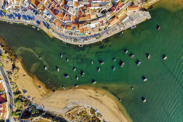 Aerial cityscape of white washed Ferragudo by Arade River