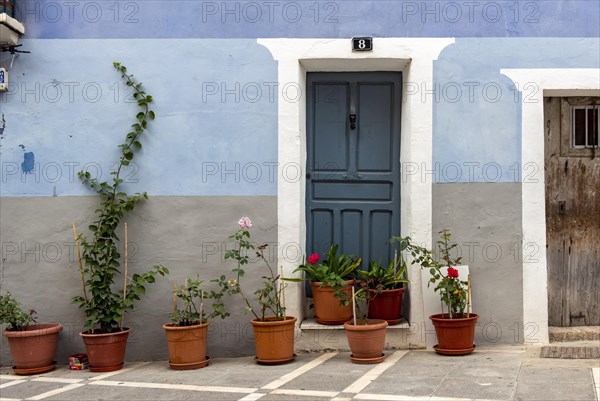 Blue door and house with flowerpots