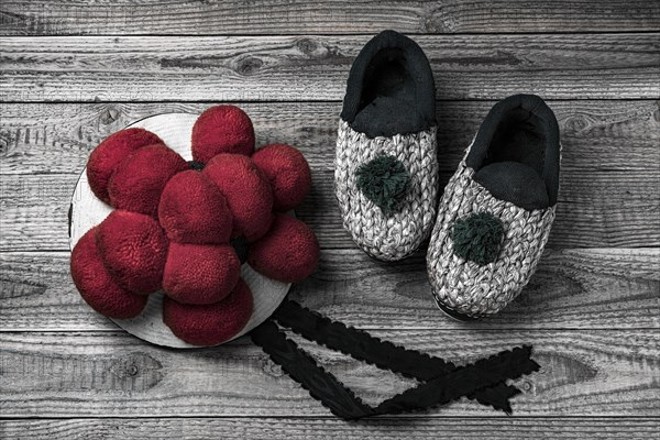 Original Black Forest Bollen hat with straw shoes on wooden background