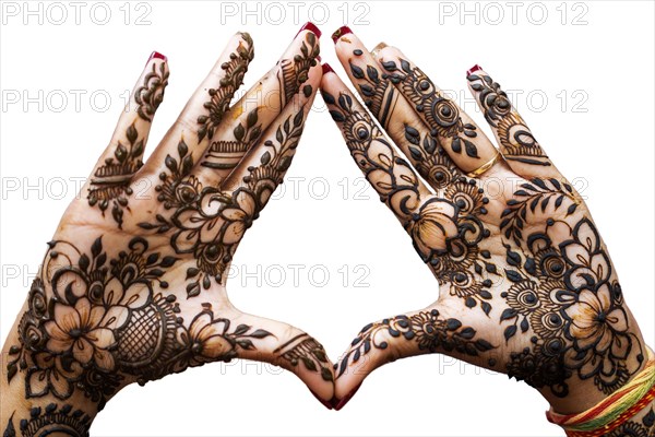 Hand of Hindu bride painted with hennas isolated on white background