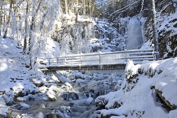 Bridge with icicles and icy waterfall