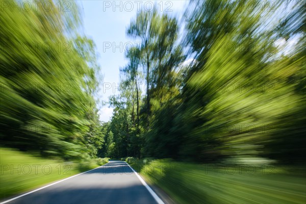 View through windscreen of moving car on winding country road