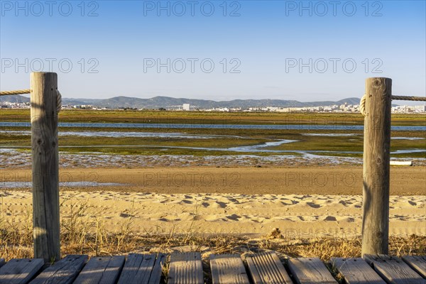 Wooden walkways with view on wetlands of Ria Formosa on Faro Beach Peninsula