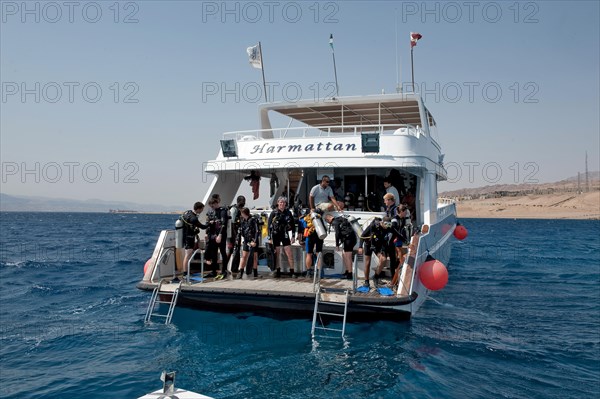 Divers standing on diving platform of dive boat