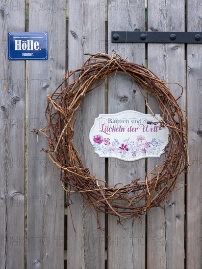 Woven wreath with sign Hell on a wooden door at the Schlossberg in Quedlinburg