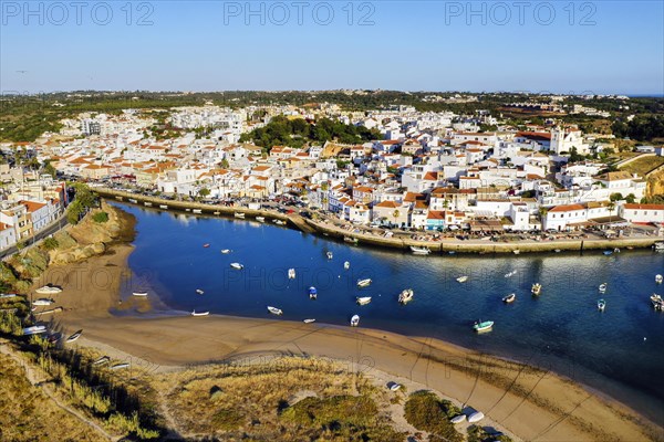 Aerial cityscape of white washed Ferragudo by Arade River