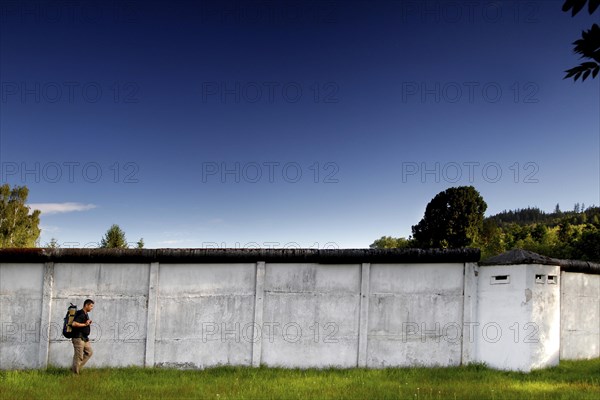 Hiker in front of border wall