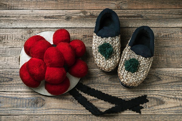 Original Black Forest Bollen hat with straw shoes on wooden background