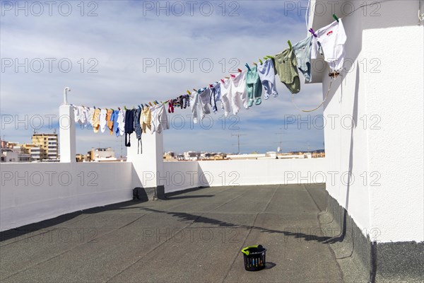 A lot of baby clothes drying on the roof in the city