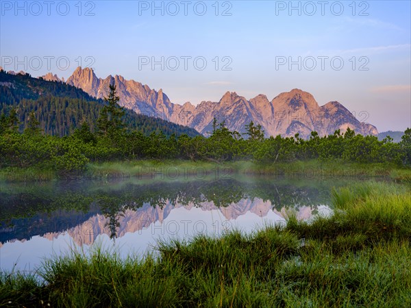 The peaks of the Gosaukamm are reflected in the moor lake at Loeckermoos