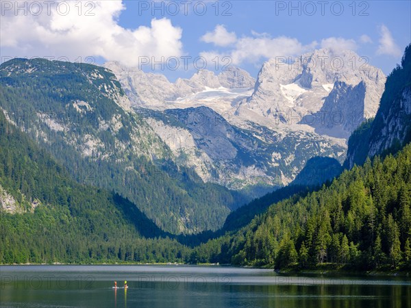 2 standup paddle boarders in Lake Gosau with a view of the Dachstein massif with the Gosau glacier
