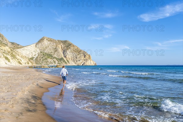 Young man walking on a beach