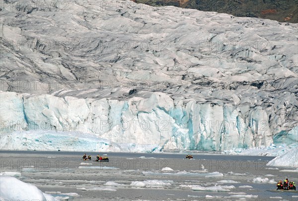 Small boats in front of ice masses and ice edge