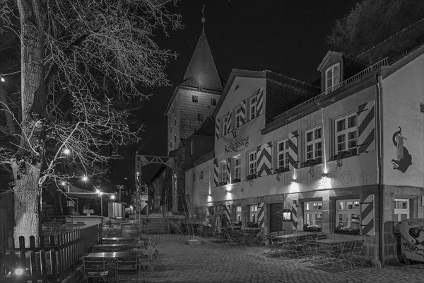 Night shot of the Kettensteg inn with historic chain footbridge from 1802