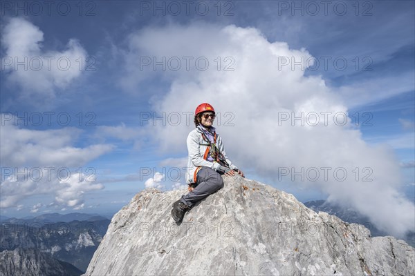 Hiker with helmet sitting on rocks