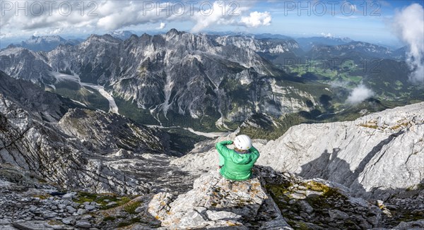 Hiker with helmet at the summit of the Watzmann