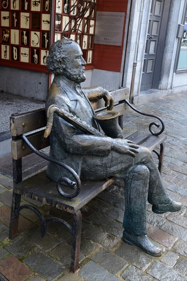 Sculpture of Adolphe Sax with saxophone in front of his birthplace
