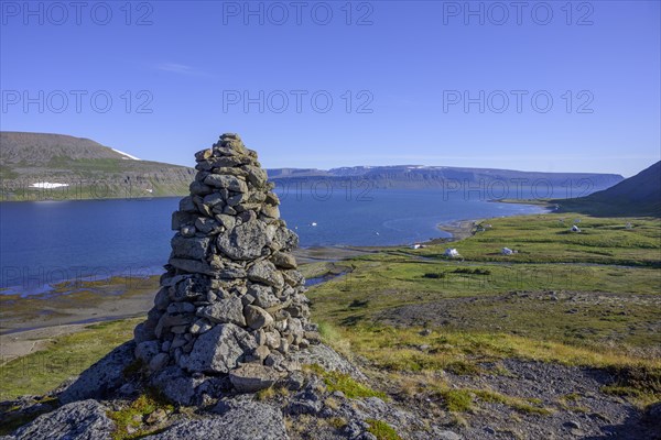 Stone man with a view of Heysteri village and Hesteyrarfjoerour