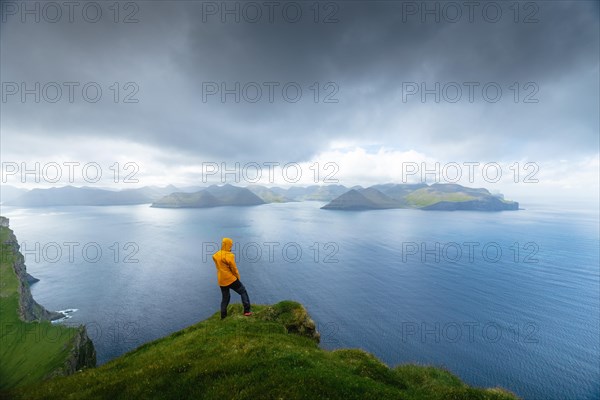 Person looking at the sea and the island of Eysturoy