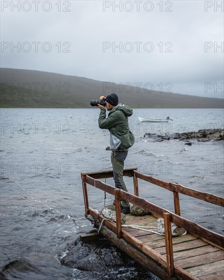 Hiker photographed on a wooden footbridge above Lake Leitisvatn