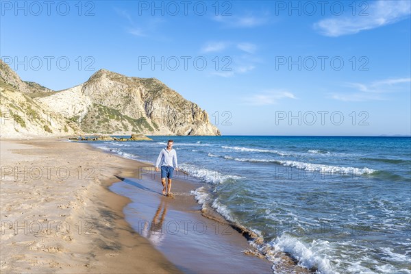 Young man walking on a beach