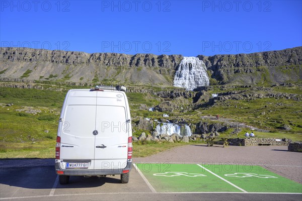 Camping bus next to parking spaces reserved for e-cars