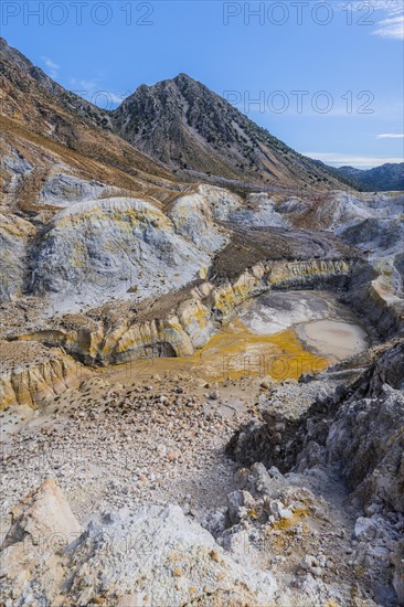 Crater with yellow discoloured sulphur stones and colourful mineral deposits