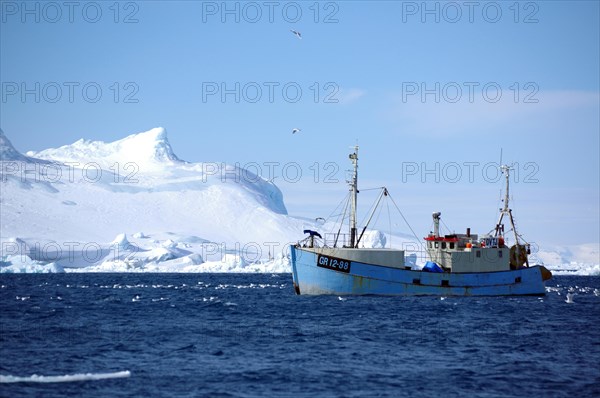 Fishing boat in front of icebergs