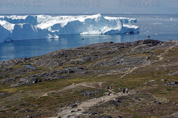 Boats in a bay with huge icebergs