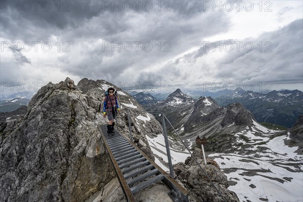 Hiker on a metal bridge on a rock