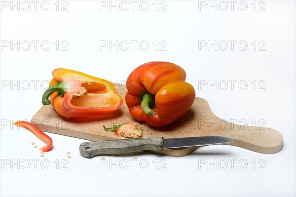 Yellow-red coloured peppers (Capsicum) on wooden board