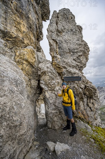 Hiker at rock formation with rock hole