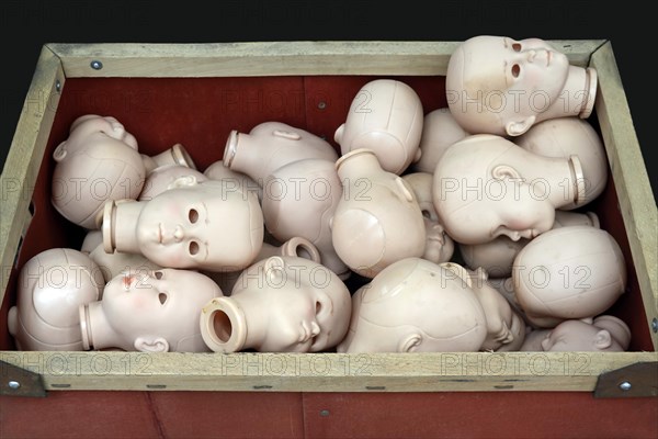 Doll heads without eyes in a box for a doll clinic